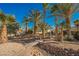 Landscaped backyard with a wooden bridge and palm trees at 328 Hedgehope Dr, Las Vegas, NV 89183