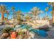 Resort-style backyard with a large pool and spa surrounded by palm trees at 328 Hedgehope Dr, Las Vegas, NV 89183