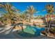 Luxury pool and spa with palm trees, rock features and a waterfall at 328 Hedgehope Dr, Las Vegas, NV 89183