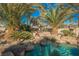 Relaxing pool area with a waterfall and palm trees at 328 Hedgehope Dr, Las Vegas, NV 89183