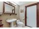 Bathroom with pedestal sink, toilet, and decorative mirror at 3495 Pama Ln, Las Vegas, NV 89120