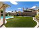 Expansive backyard featuring artificial turf, mature plants, and a pergola at 3817 W Red Coach Ave, North Las Vegas, NV 89031