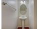 Small bathroom with pedestal sink, oval mirror, and dark wood floor at 3968 Moon Tango St, Las Vegas, NV 89129