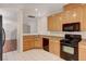 Kitchen with light wood cabinets, granite countertops and black appliances at 3968 Moon Tango St, Las Vegas, NV 89129