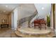 Stunning curved staircase with wrought iron railing and piano landing at 4 Bloomfield Hills Dr, Henderson, NV 89052