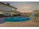 Inviting backyard pool with slide and covered patio area, perfect for outdoor entertaining and relaxation under a colorful sky at 4008 Snead Dr, Las Vegas, NV 89107