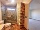 Modern bathroom featuring a stone shower with glass doors and decorative wood accents at 422 Waterbrook Dr, Henderson, NV 89015