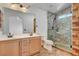 Bathroom features double sinks, stone-walled shower with a glass door and wood-look tile flooring at 422 Waterbrook Dr, Henderson, NV 89015