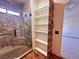 Bathroom with walk-in shower, built-in shelving, and wood-like accent wall at 422 Waterbrook Dr, Henderson, NV 89015