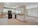 Spacious kitchen with white cabinets, black appliances, and views of the living area at 422 Waterbrook Dr, Henderson, NV 89015