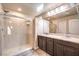 Bathroom featuring dual sinks with stone countertop, walk-in shower with glass door at 5490 Tulip Hill Ave, Las Vegas, NV 89141