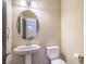 Clean bathroom with pedestal sink, toilet, and an oval mirror at 5490 Tulip Hill Ave, Las Vegas, NV 89141