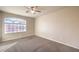 Empty bedroom showcasing carpet flooring, light walls, ceiling fan, and natural lighting at 5490 Tulip Hill Ave, Las Vegas, NV 89141