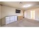 Spacious bedroom with neutral carpet, dressers, a ceiling fan and TV at 5490 Tulip Hill Ave, Las Vegas, NV 89141