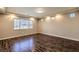 Empty bedroom with light walls, wood floors, and a large window at 5490 Tulip Hill Ave, Las Vegas, NV 89141
