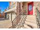 Front entrance with red door and wrought iron railing at 5490 Tulip Hill Ave, Las Vegas, NV 89141