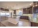 Modern kitchen featuring a large island, stainless steel appliances, and dark cabinets at 5490 Tulip Hill Ave, Las Vegas, NV 89141