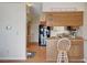 Kitchen with breakfast bar, modern black refrigerator, and wood-look floors and cabinetry at 5767 Tabitha Ave, Las Vegas, NV 89156