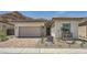 Charming single-story home with a two-car garage, stone accents, and a desert-landscaped front yard at 65 Ibiza Lake Dr, Henderson, NV 89011