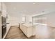 Modern kitchen boasts an island with seating, white cabinets, stainless steel appliances, and wood floors at 65 Ibiza Lake Dr, Henderson, NV 89011