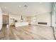 Open-concept living space with wood floors, modern fireplace, recessed lights, and access to the kitchen at 65 Ibiza Lake Dr, Henderson, NV 89011