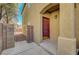 Close-up view of the red front door, set in an alcove with stylish exterior lighting and stucco walls at 8040 Marshall Canyon Dr, Las Vegas, NV 89166