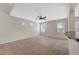 Bright living room with tile flooring, ceiling fan, and a partial view of the kitchen and back patio at 8040 Marshall Canyon Dr, Las Vegas, NV 89166