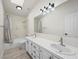 Bathroom with double sinks, a large mirror, and a shower/tub combo with tile surround at 908 Primrose Ln, Henderson, NV 89011