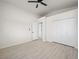 Bedroom featuring light wood-look floors, closet, ceiling fan, and multiple doors at 908 Primrose Ln, Henderson, NV 89011