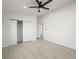 Bedroom featuring light wood-look floors, closet, ceiling fan, and multiple doors at 908 Primrose Ln, Henderson, NV 89011