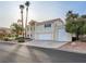 Exterior view of a two-story house featuring a well manicured yard and an attached three car garage at 908 Primrose Ln, Henderson, NV 89011