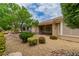 Landscaped backyard with gravel, mature trees, and a covered patio at 10505 Novella Ct, Las Vegas, NV 89135