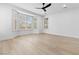 Bright bedroom with bay window, wood-look floors, and a ceiling fan at 10505 Novella Ct, Las Vegas, NV 89135