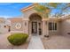 Front view of charming home featuring arched entryway and desert landscaping at 10813 Black Ledge Ave, Las Vegas, NV 89134