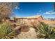 Desert landscaping surrounds this single story home with stucco siding and tile roof at 210 Bristle Cone, Pahrump, NV 89048