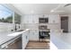 Modern white kitchen with stainless steel appliances and quartz countertops at 2113 La Harve Dr, Las Vegas, NV 89106