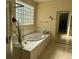 Relaxing bathroom featuring a large tub and a glass block window at 2273 Moresca Ave, Henderson, NV 89052