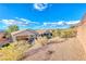 Desert landscaped backyard with covered patios and views of neighboring homes under a blue sky with clouds at 2571 Jada Dr, Henderson, NV 89044