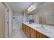 Bathroom with double sinks, wood cabinets, and a walk-in shower at 2571 Jada Dr, Henderson, NV 89044