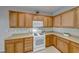 Classic kitchen featuring well-lit wood cabinetry paired with modern white appliances at 2571 Jada Dr, Henderson, NV 89044