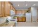 Efficient kitchen with oak cabinets and white appliances at 2571 Jada Dr, Henderson, NV 89044