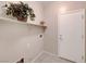 A well-lit laundry room featuring tile floors, storage shelf with decor, and utility connections at 2571 Jada Dr, Henderson, NV 89044