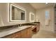 Bright bathroom featuring dual sinks and large, lighted mirrors at 2680 Mystere Ct, Las Vegas, NV 89117