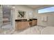 Bright bathroom with a marble floor, modern vanities, large mirrors, and a peek into the main bedroom at 2680 Mystere Ct, Las Vegas, NV 89117