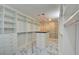 Custom walk-in closet with marble floors, modern shelving, and an island dresser with black countertop at 2680 Mystere Ct, Las Vegas, NV 89117