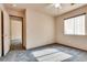 Bedroom featuring gray carpet, window, ceiling fan, and open doorway to another room at 2935 Kensington St, Las Vegas, NV 89156