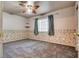 Bedroom featuring gray carpet, ceiling fan, and a window with curtains and an accent wall at 2935 Kensington St, Las Vegas, NV 89156