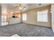 Open-concept living room with neutral carpet, bright windows, and ceiling fan at 2935 Kensington St, Las Vegas, NV 89156