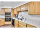 Kitchen with oak cabinets, tile counters, and stainless steel sink at 348 Wild Plum Ln, Las Vegas, NV 89107