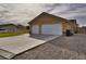 A two-car garage with a wide driveway and desert landscaping on a sunny day at 360 S Blagg Rd, Pahrump, NV 89048